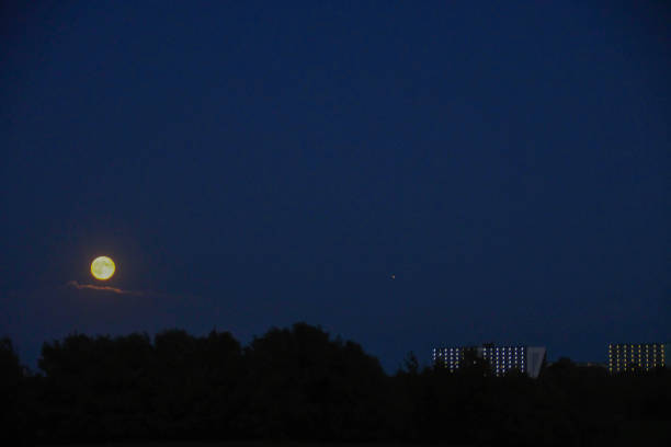 Rising full hunter's moon over the city