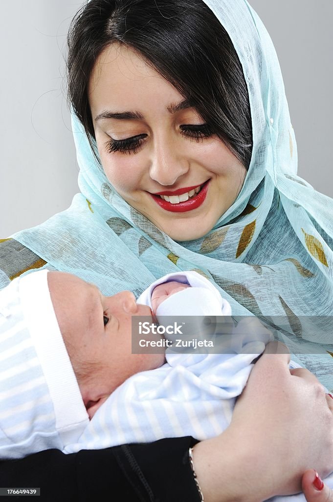 Portrait of a woman holding her newborn baby Arabic woman with her baby Middle Eastern Culture Stock Photo