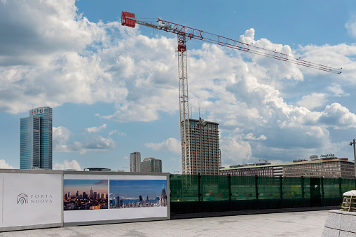 Piazza Gae Aulenti, Milan, Italy - August 23, 2014. Urban panorama, architecture. Skyscraper and buildings in the city center. In the background cranes and new construction site.