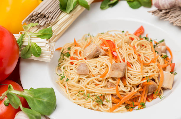 istock noodles with vegetables and garnish on white plate 176650752