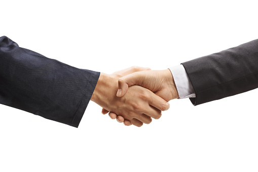 Handshake of two businessmen on the background of bright boardroom, partnership concept, close up