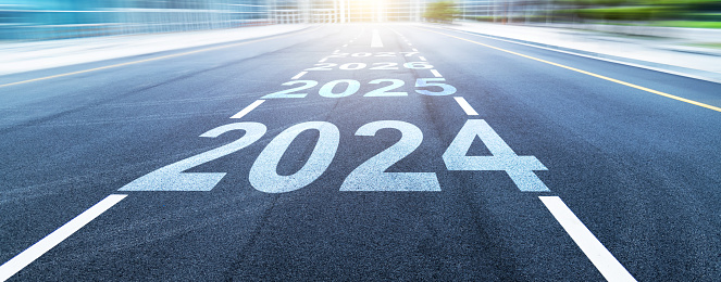 Black asphalt road with new year numbers 2024, 2025 to 2027 with white dividing lines