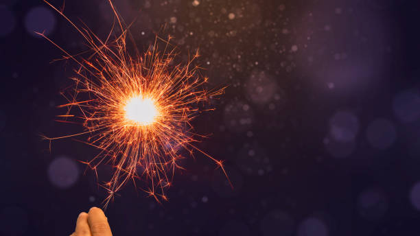 istock Human hand holding sparkler with colorful blurred light 1766513302