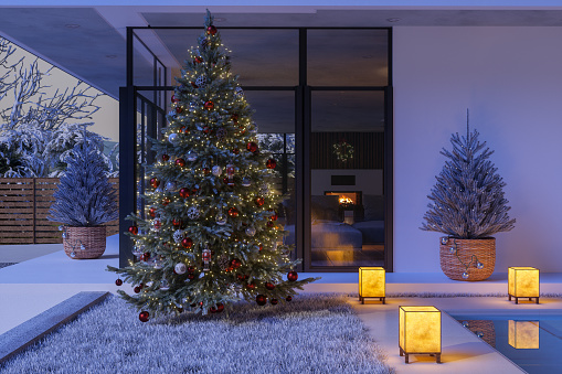 Close-up View Of Luxury Villa Exterior Decorated With Christmas Tree And Ornaments In Snowy Weather At Night