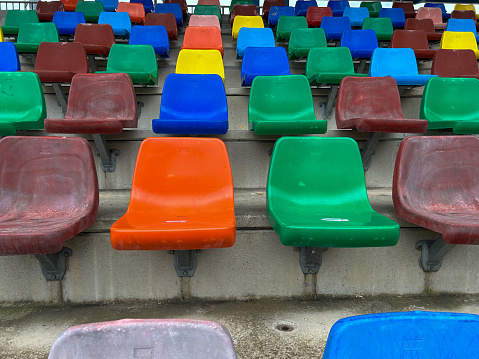 rows of plastic seats of different colors forming a stand for people to sit.