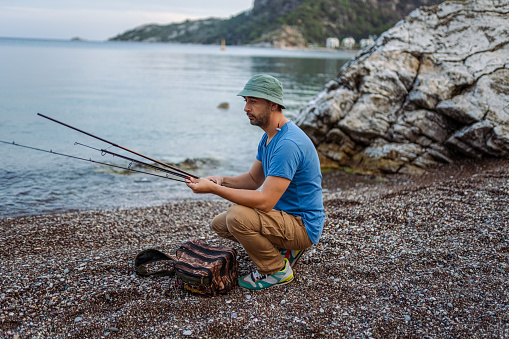 Portrait of a fisherman with a fishing rod on his shoulder on the