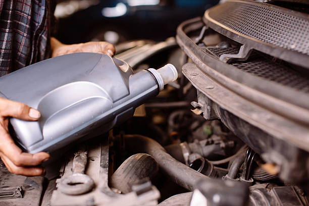 istock Car mechanic fills engine oil 176658048