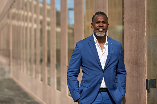 Horizontal portrait with copy space of an African american mature businessman looking proud standing outdoors