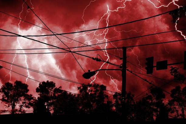 Idyllic landscape featuring trees with electrical lines and bright red lightning in the background