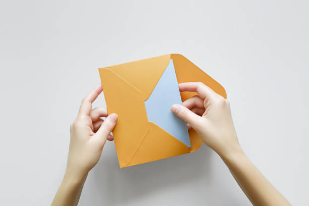 istock woman takes out a postcard from an envelope, top view 1766611628