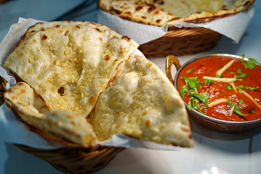 The traditional Indian food, roti naan served with butter chicken curry