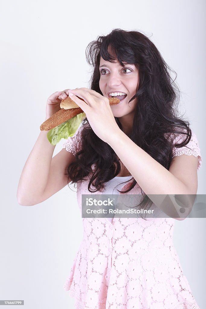good appetite Young woman is a bun topped with Wiener schnitzel and salad Adult Stock Photo