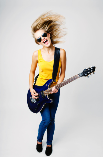 Teenage woman playing on guitar