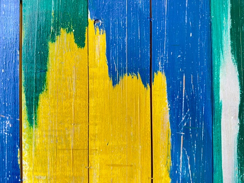 Green, yellow, blue on wood texture and background