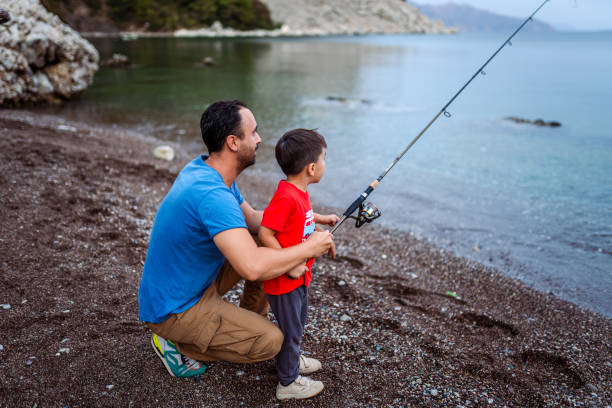 istock Man fishing  with son at beach for relaxation 1766627633