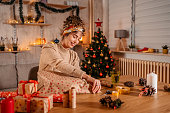 Young Woman Wrapping Christmas Gifts At Home