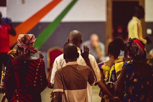 Abidjan, Ivory Coast – February 26, 2023: A group of people in a church in Abidjan, Cote d'Ivoire, praying together