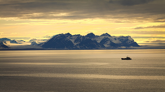 A view on a glacier and on a lonely ship somewhere in Svalbard, Arctic Sea