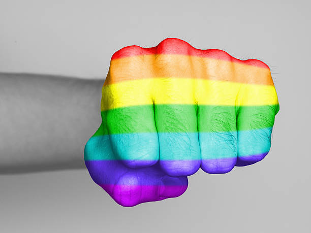Fist of a man punching, rainbow flag pattern stock photo