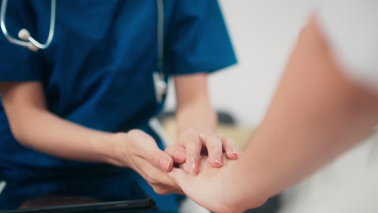 Close up hands of kind doctor touching young female patient hands to give empathy and encourage, Female caregiver nurse providing care and giving advice to woman during home visit