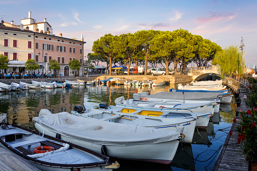 Holidays in Italy -  Scenic view of marina Porto Vecchio with motor boats and Venetian bridge in historical centre of Desenzano del Garda town, Lombardy