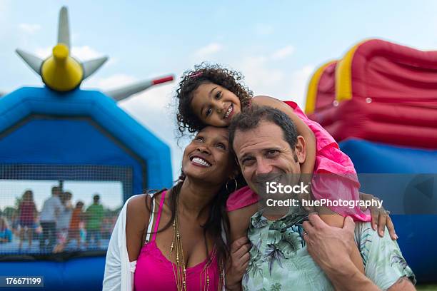 Young Parents And Child At A Festival With Inflatables Stock Photo - Download Image Now