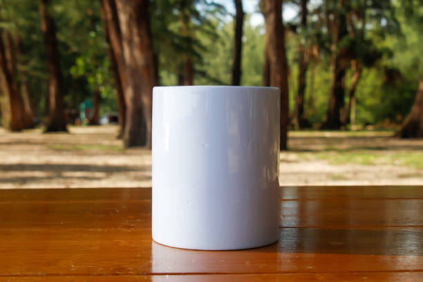 istock A white mug placed on a log with a view of nature in the background. 1766715101