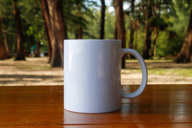 istock A white mug placed on a log with a view of nature in the background. 1766715131