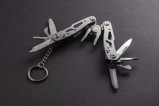 multitool pliers on dark background. pocket knife multi-tool cut out