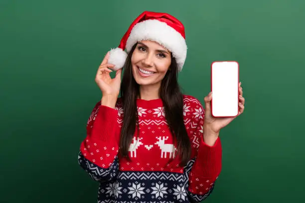 Photo of excited pretty woman elf wear x-mas pullover chatting apple samsung iphone device empty space isolated green color background.
