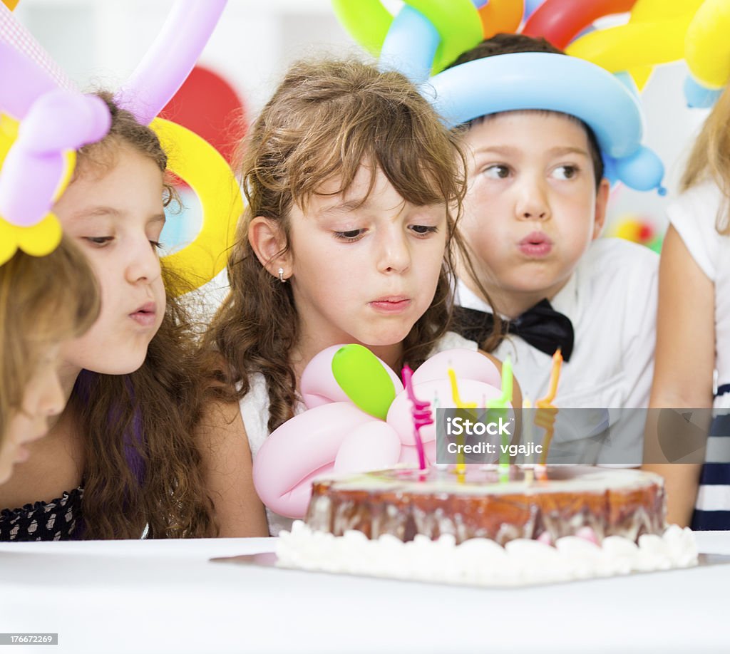 Radosny dzieci dmuchającego świeczki urodzinowe. - Zbiór zdjęć royalty-free (6-7 lat)