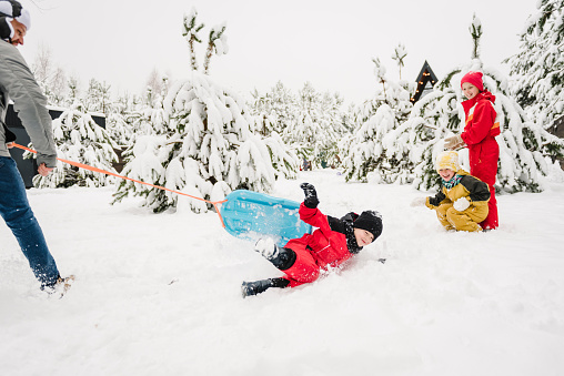 Three multi-ethnic girls on sledge having fun in snow