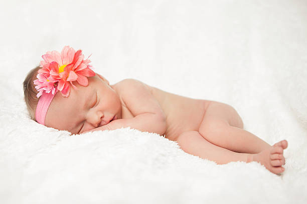 istock Sleeping Newborn Baby on White with Pink Flower 176672492