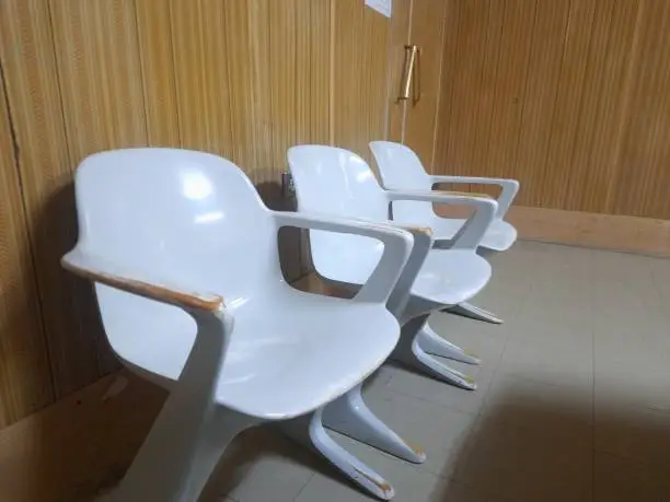 Office Furniture, three old plastic chairs with a futuristic style in front of a 1970s-style wall