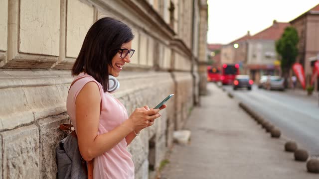 Young Woman Texting On Her Smartphone On The Street