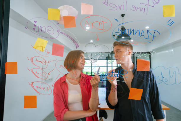 istock Couple of business people brainstorming idea by using sticky note. Immaculate. 1766742945