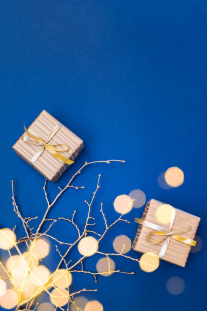 istock Flat lay christmas composition with golden gift box and christmas decorations, garland on a blue background. Winter holiday background with copy space 1766744553