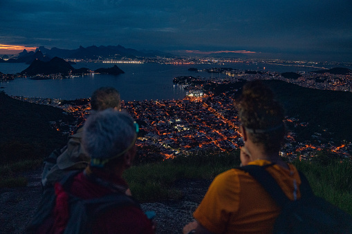 Hikers enjoying the breathtaking view of the city at night