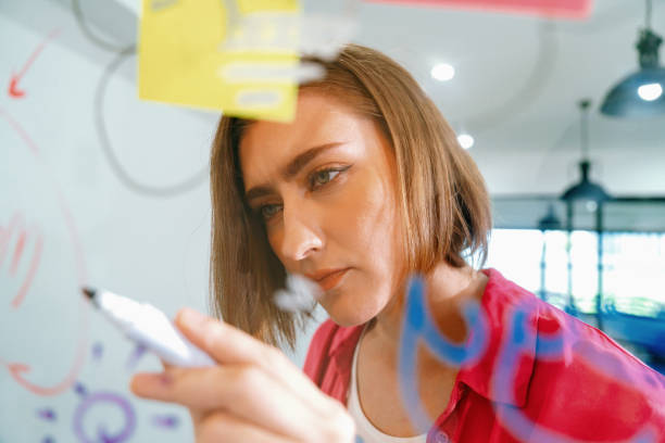 istock Young beautiful business leader writing marketing idea on board. Immaculate. 1766758038