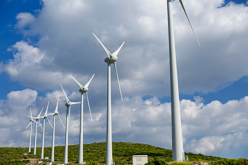 Aerial view large group of eco system wind turbines power generation station on green field in rural landscape in countryside