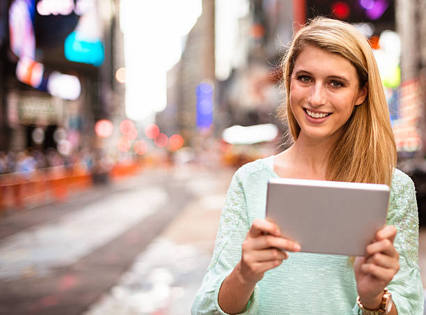 social networking in times square-new york city - digital tablet travel destinations new york state times square stock-fotos und bilder