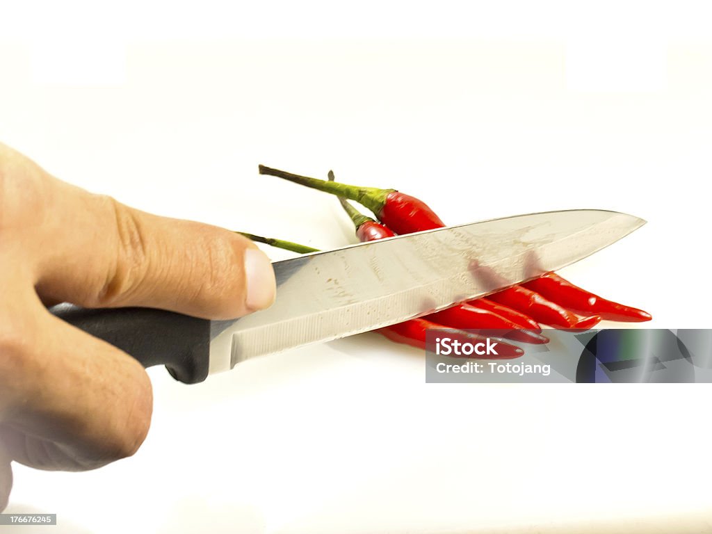 Red Chili peppers with hand of someone and knife Close-up Stock Photo