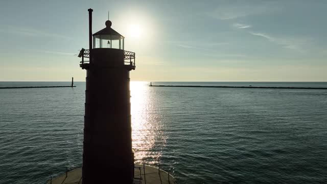 A small Bay on the coast of Michigan, guarded by a sturdy lighthouse.