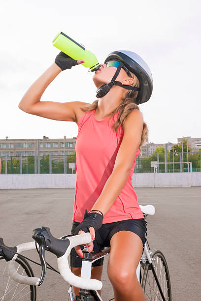 istock Cyclist woman takes a water break 176676823