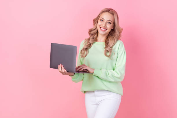 istock Photo of charming girlfriend holding netbook using modern device for studying remote university learning isolated on pink color background 1766777866