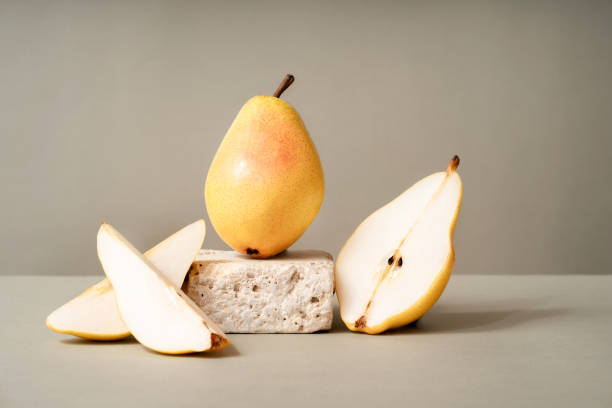 istock Podium for exhibitions and product presentations, material: stone, fruit. Beautiful green background with yellow pears. Abstract minimal empty background composition for product presentation. 1766780576