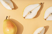 Fruity pears on a beige background. Yellow pears pattern. Beautiful background from natural fruit.