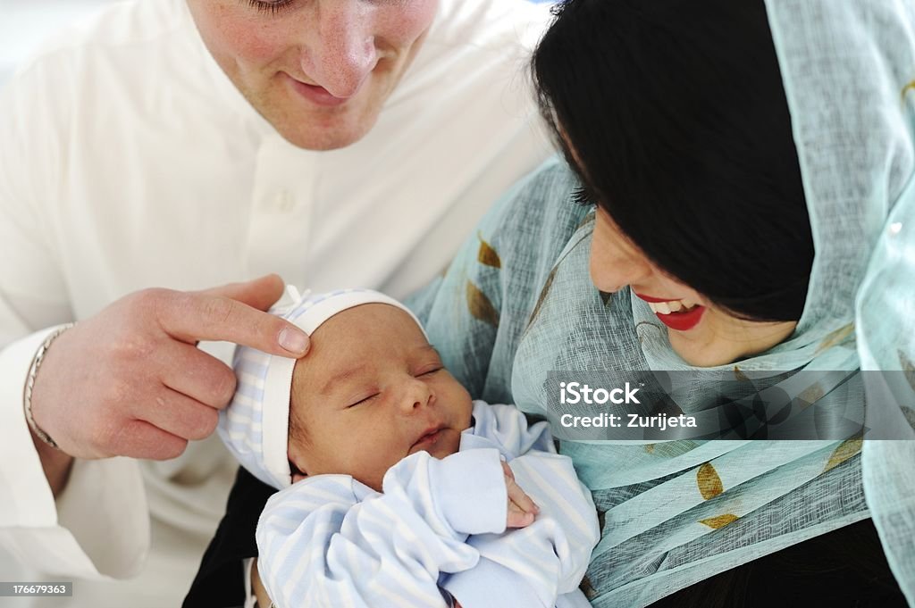 Arabic Muslim couple with new baby at home Arabic Mother and Father with baby at home Baby - Human Age Stock Photo