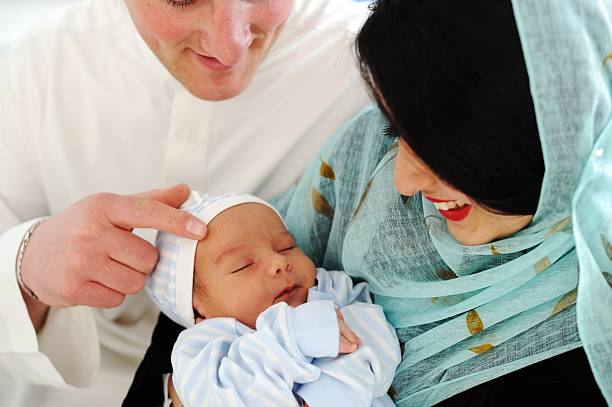 Arabic Muslim couple with new baby at home stock photo