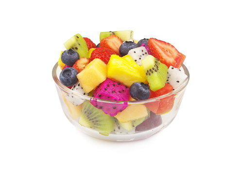 Fruit salad in glass bowl isolated on white background.